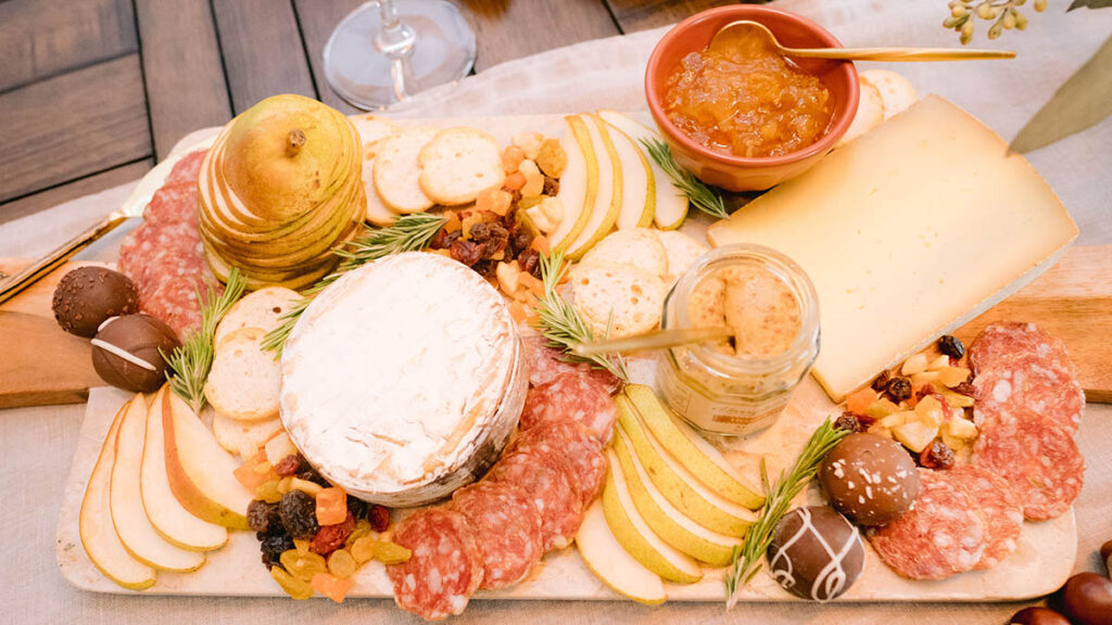 Fall charcuterie board with pears, cheese, meat, and other snacks.
