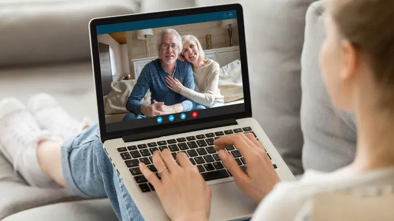 Grandparents day with a woman chatting virtually with her grandparents on the computer.