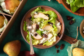 Pear and blue cheese salad in a bowl next to a box of pears.