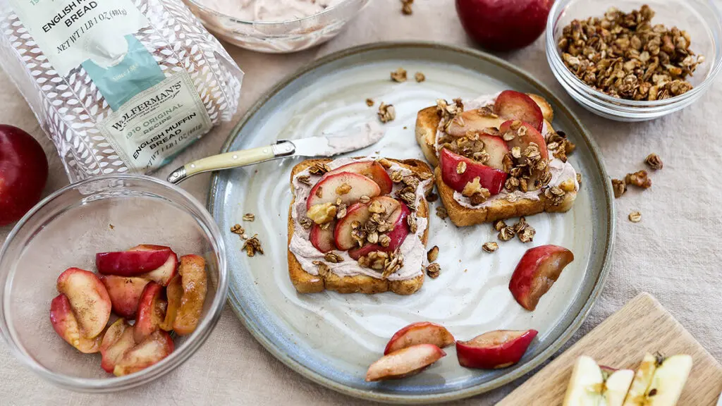 apple crisp image - apple crisp toast on a grey plate with ingredients surrounding it.