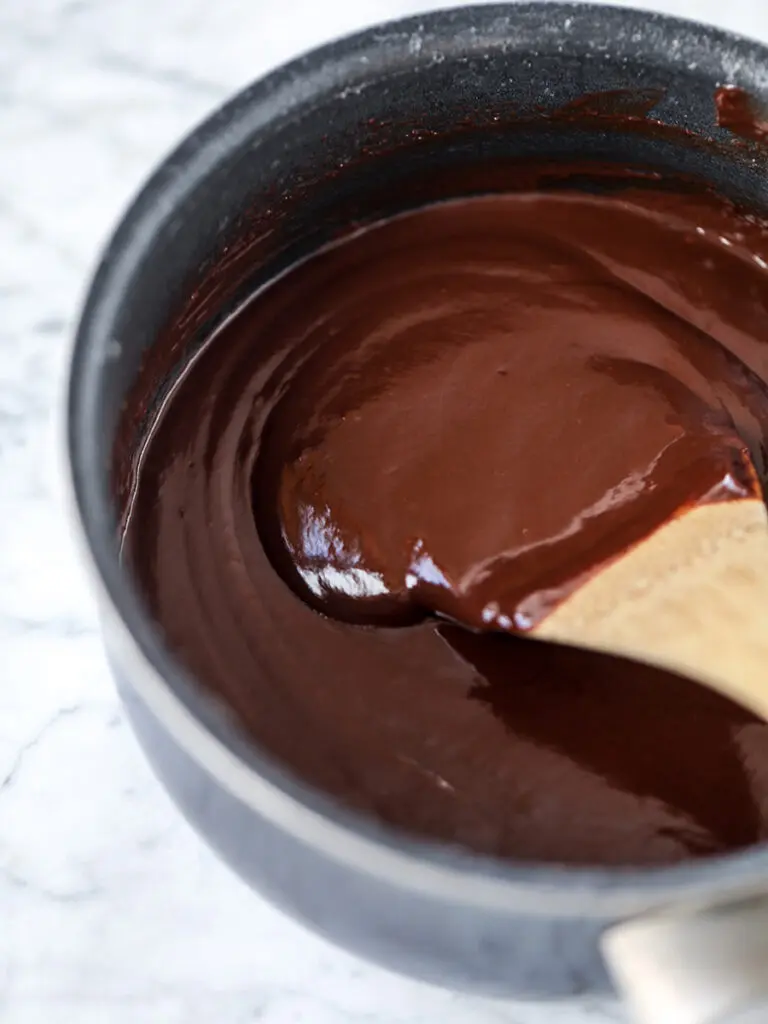 Chocolate cherry cheesecake in the process of melting chocolate.