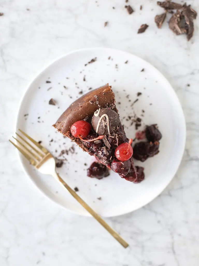 Chocolate cherry cheesecake slice on a plate.