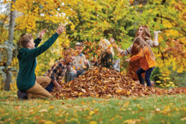 fall leaves image - kids playing in pile of leaves outside