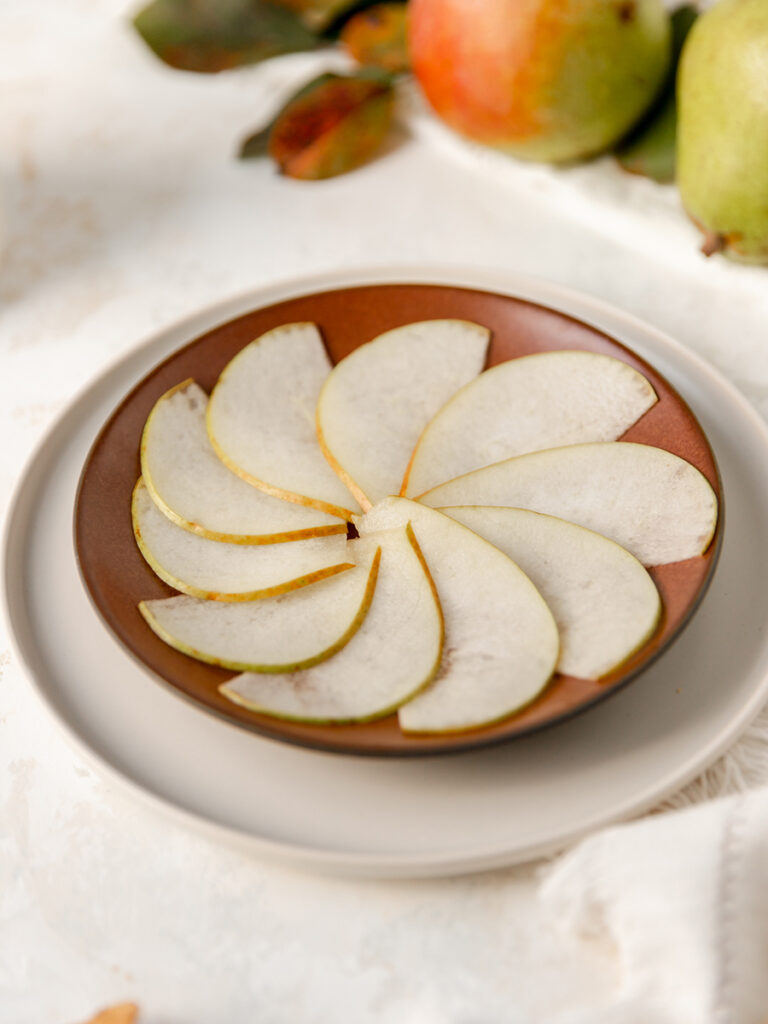 Thinly sliced pears in a pinwheel shape on a plate.