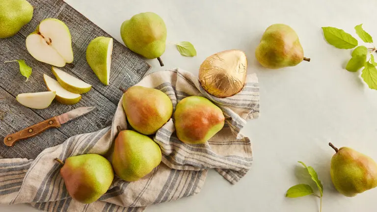 How to ripen pears with several whole and sliced pears on a counter.