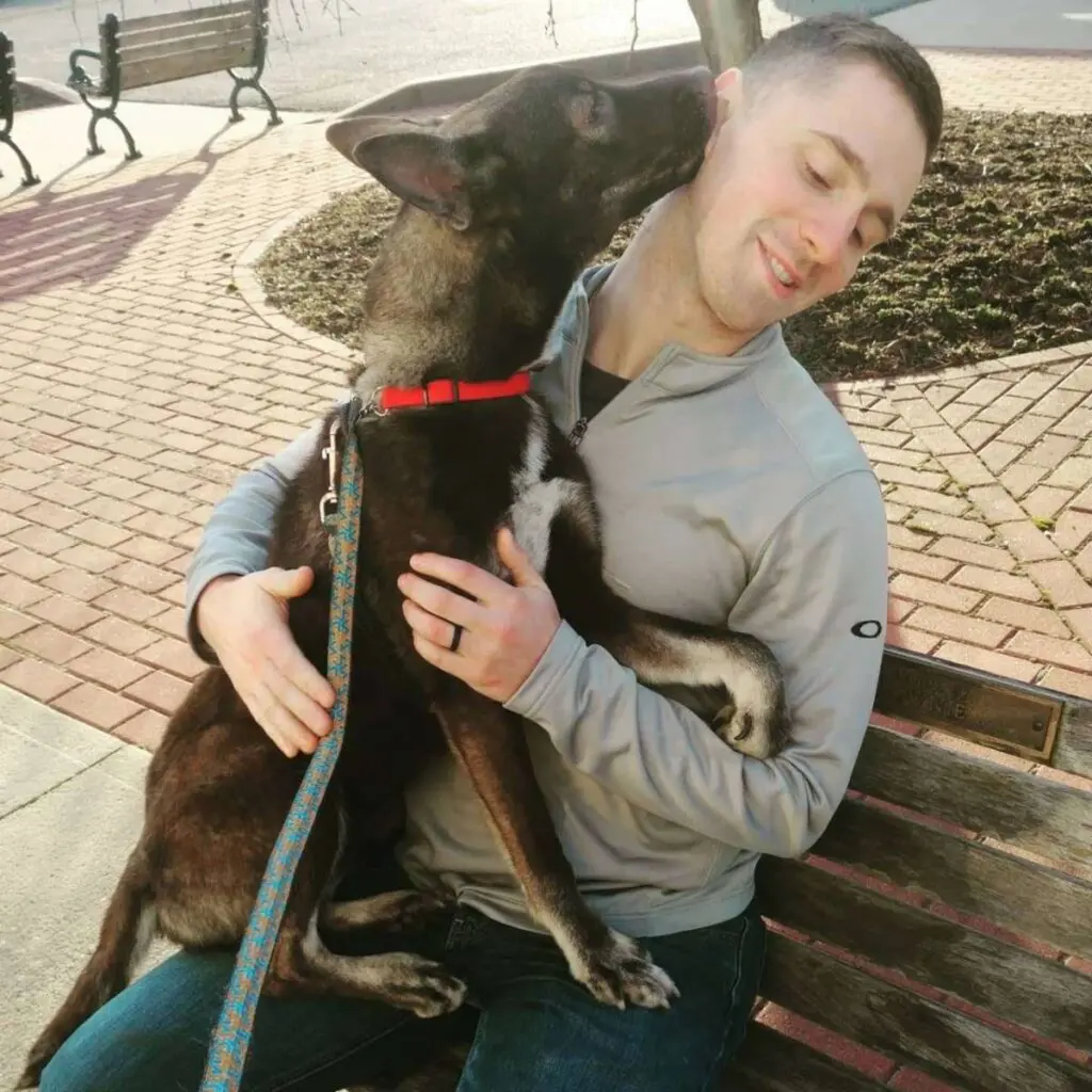 shelter animals image - dog sitting on man's lap licking his face.