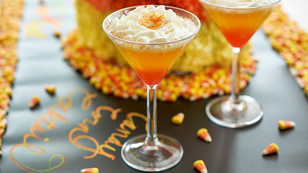 candy corn cocktail image - candy corn martini with candy corn in the background