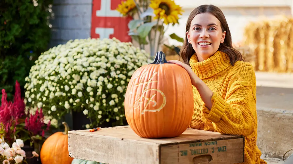 A photo of facts about pumpkins with a woman showing her carved pumpkin that has the Harry & David logo
