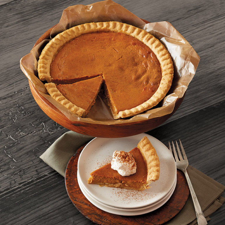 A photo of facts about pumpkins, a pumpkin pie on a stand with a slice of pie on a plate in front.