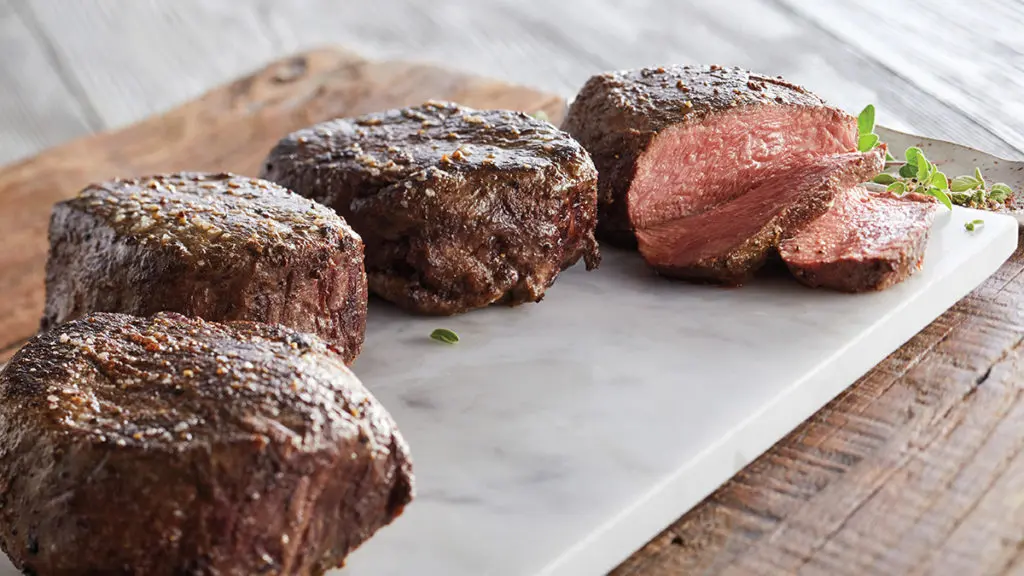 filet mignon image - four pieces of filet mignon on a white counter top