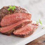 filet mignon image - sliced filet mignon on a cutting board with fresh herbs
