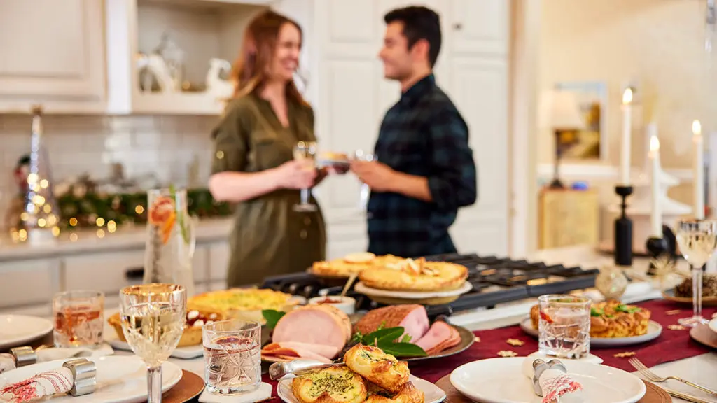 A photo of Thanksgiving dinner with a couple in the background