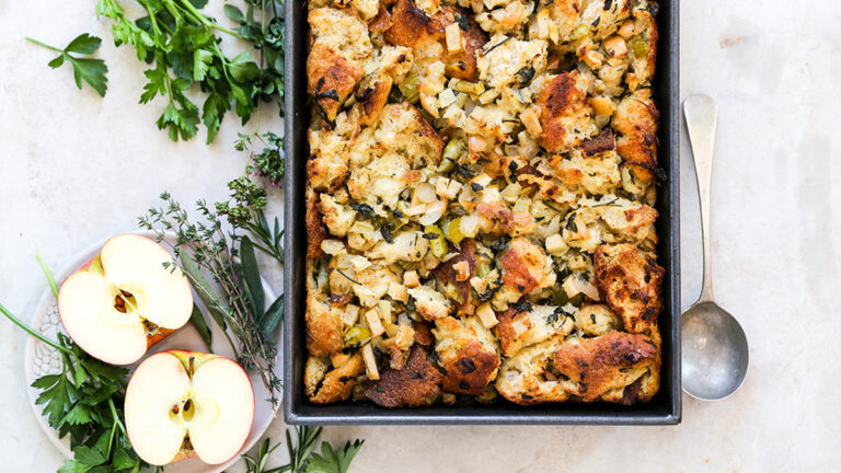 A photo of apple stuffing with an apple cut in half sitting next to it