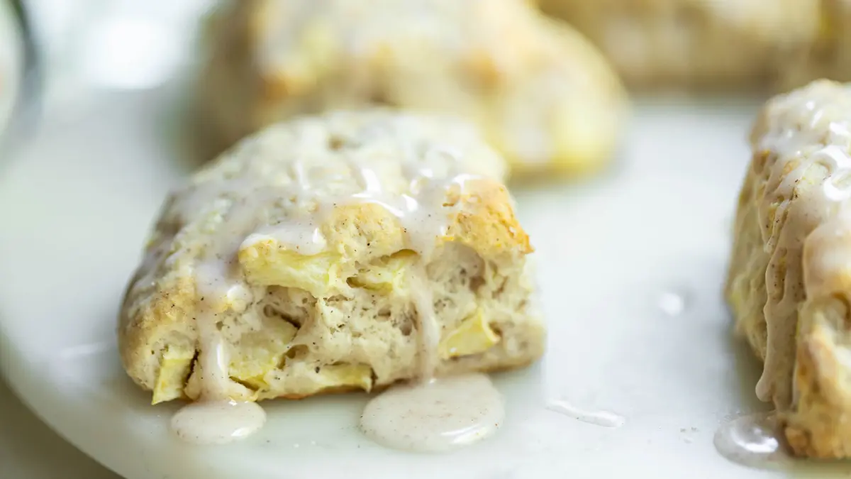 A photo of an apple scone recipe with a closeup of freshly iced scones