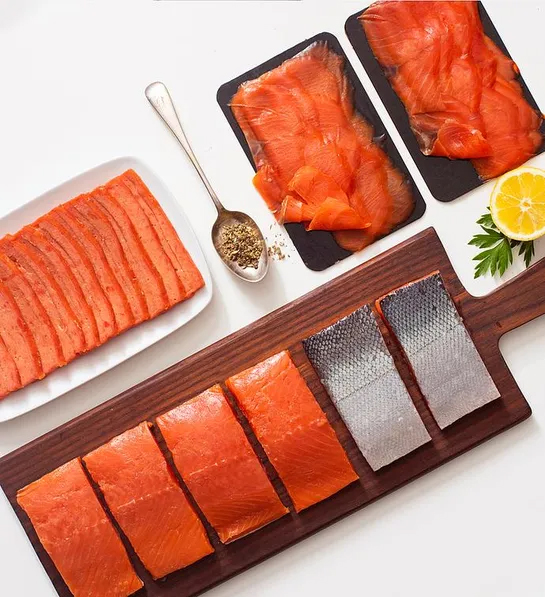 Regalos de Navidad para él con varios tipos de salmón crudo sobre una mesa.