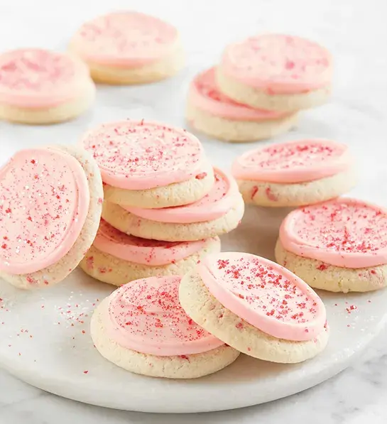 Gifts under $30 with a stack of pink-frosted cookies.