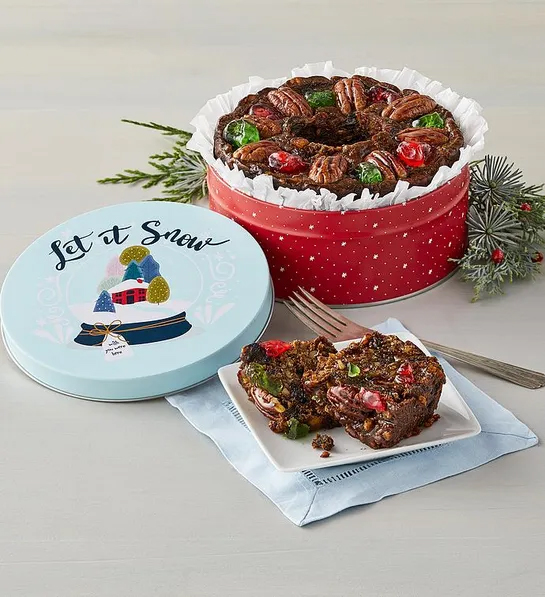 Gifts under $30 with a fruitcake in a Christmas themed tin.