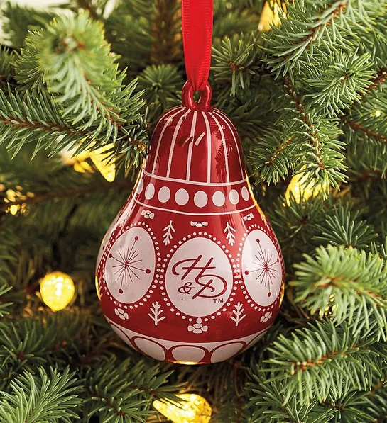Gifts under $30 with a Christmas ornament shaped like a pear hanging on a Christmas tree.