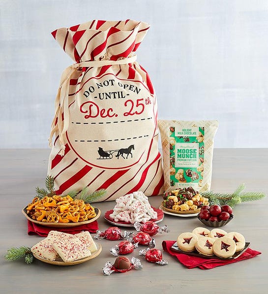 A photo of gifts under $50 with a sack surrounded by cookies, chocolate, and snacks.