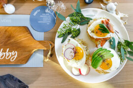 Hanukkah brunch table with a plate of eggs Benedict next to a personalized cutting board.