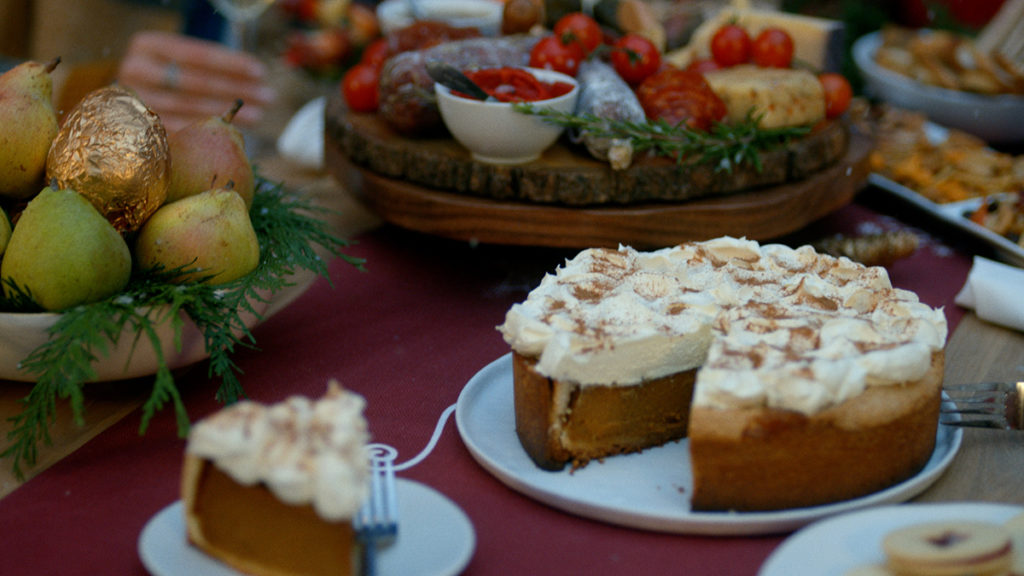 A photo of a holiday party with a spread of dessert and charcuterie