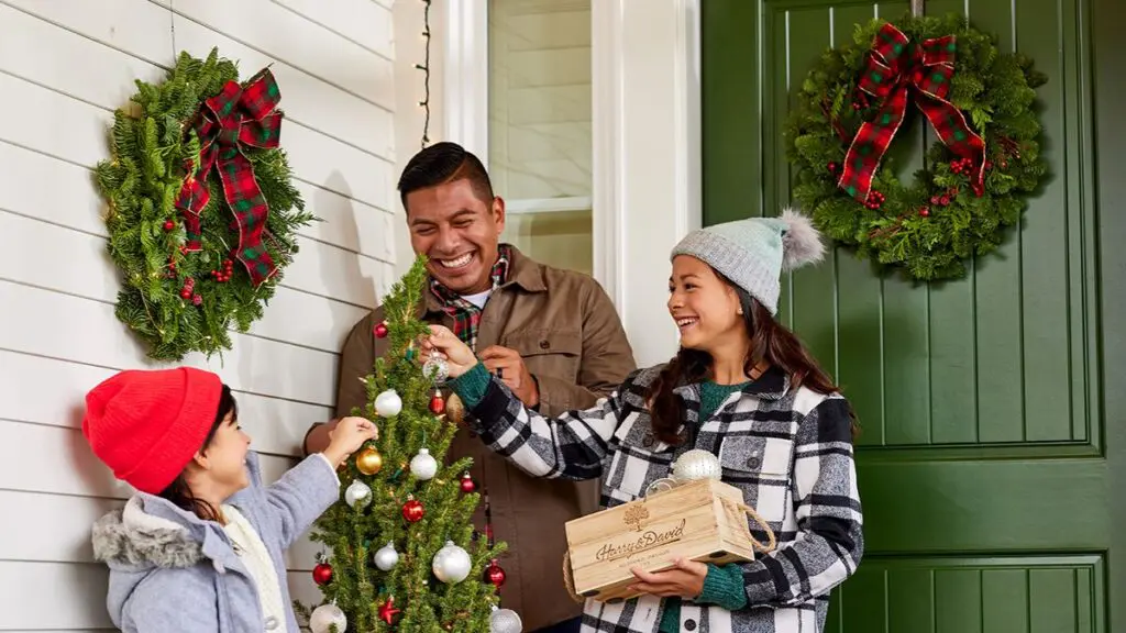 A photo of a holiday checklist with a family decorating a small Christmas tree on their porch