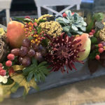 A photo of a pear tablescape with fruit and fall foliage