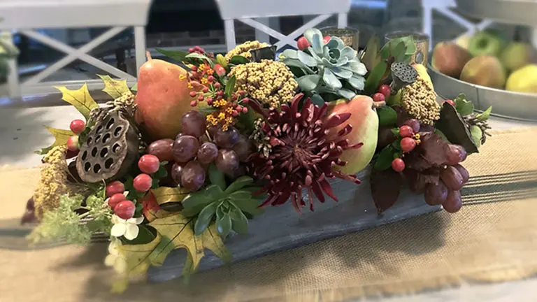 A photo of a pear tablescape with fruit and fall foliage