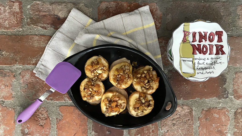 A photo of roasted pears recipe with a bowl full of roasted pears with a stack of napkins next to it