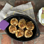 A photo of roasted pears recipe with a bowl full of roasted pears with a stack of napkins next to it