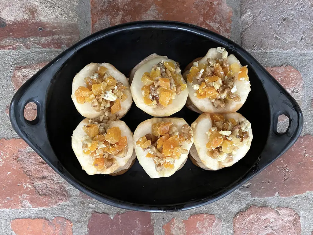 A photo of roasted pears recipe with a bowl full of unbaked pears with cookie crumbles on the top