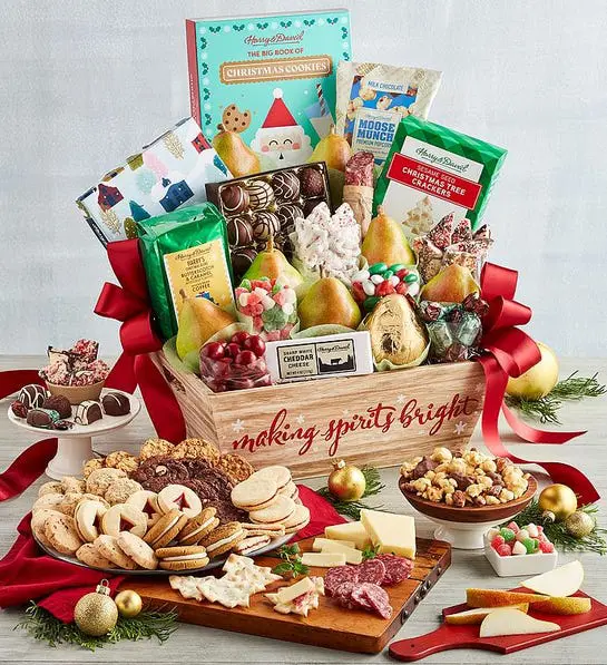 A photo of the supreme Christmas gift basket overflowing with chocolate, cookies, pears, and other snacks with a spread of the same items in front on plates and in bowls.