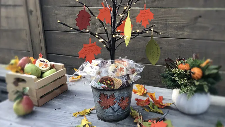 A photo of a thanksgiving tree surrounded by cookies and fruit