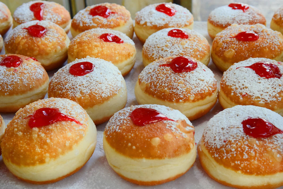 Traditional Hanukkah foods sufganiyots on a tray.