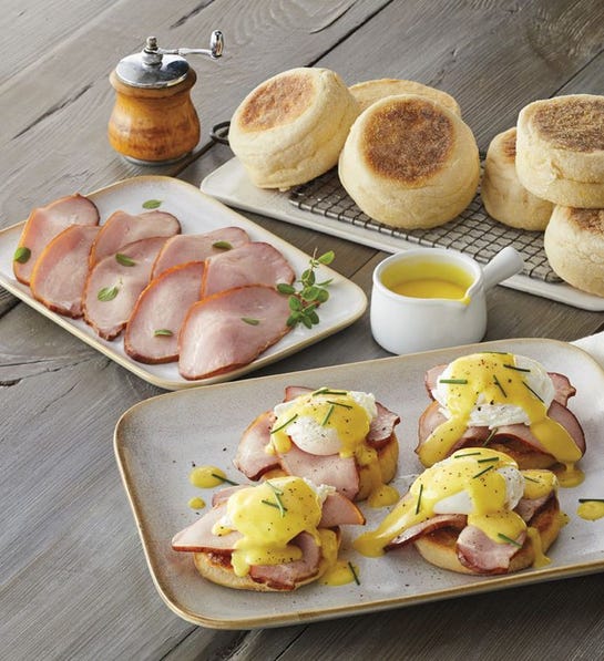 A photo of birthday gift ideas with a plate of eggs Benedict with the ingredients for eggs Benedict on plates behind it.