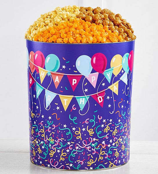 A photo of birthday gift ideas with a tin full of popcorn and decorated with the phrase "happy birthday."