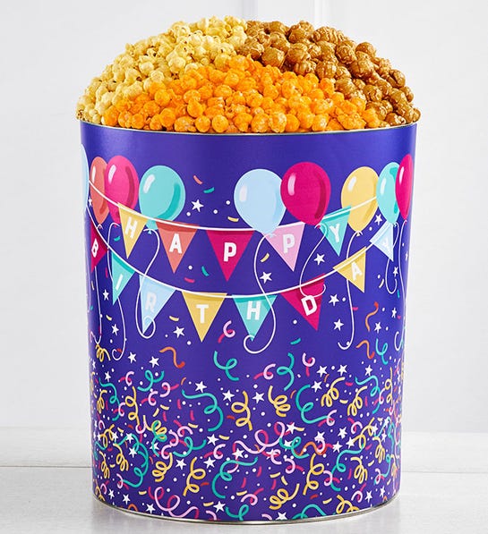 A photo of birthday gift ideas with a tin full of popcorn and decorated with the phrase happy birthday