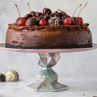 Chocolate truffle cherry cheesecake on a platter.
