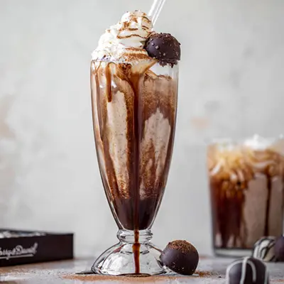 Chocolate truffle milkshake in a tall glass.