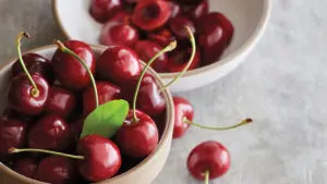 A photo of healthy fruit with two bowls of cherries