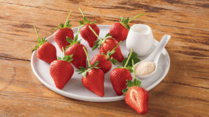 A photo of healthy fruit with a plate full of strawberries