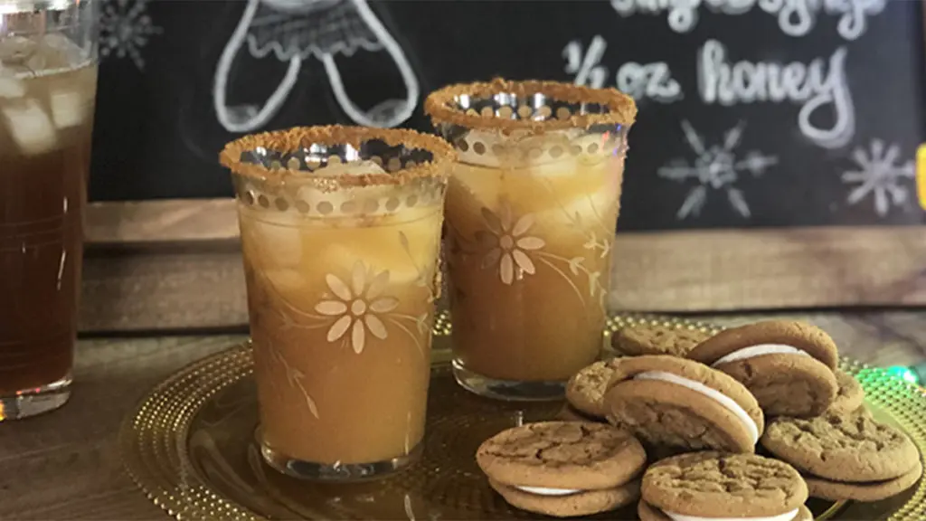 A photo of a craft cocktail with a plate of cookies in front