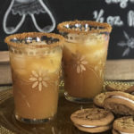 A photo of a craft cocktail with a plate of cookies in front