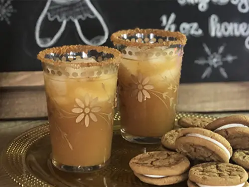 A photo of a craft cocktail with a plate of cookies in front