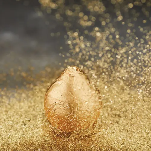 Golden wrapped pear surrounded by gold sparkles.