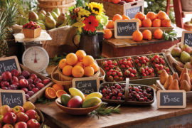 A photo of healthy fruit with baskets and boxes of fruit displayed on several tables