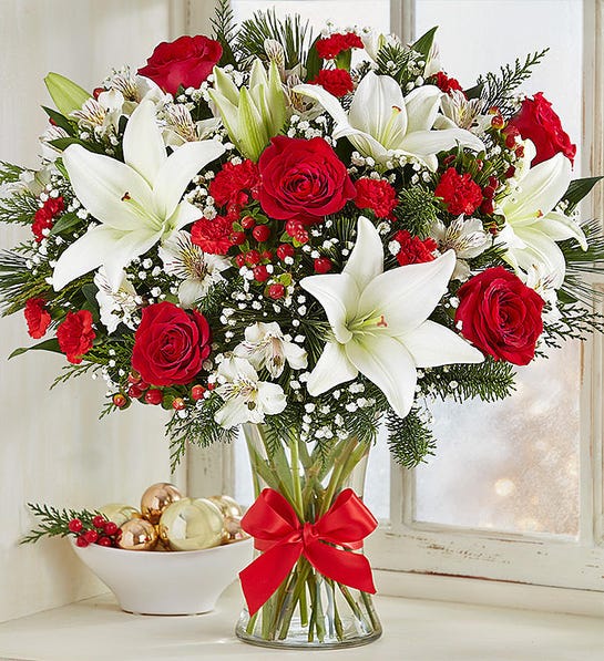 A photo of last minute gifts with a vase of Christmas colored flowers