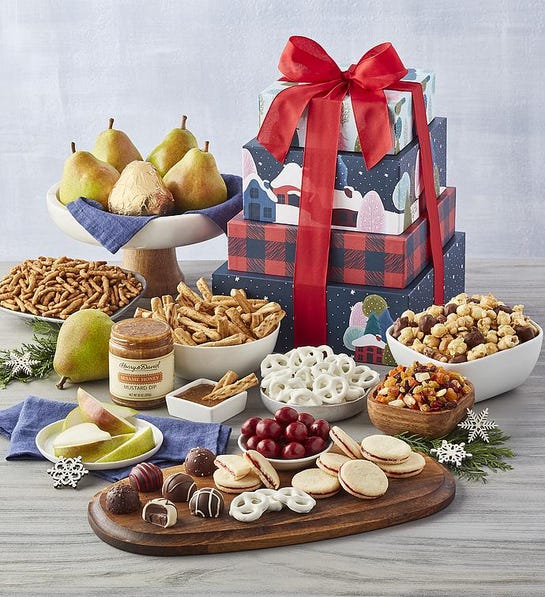 A photo of last-minute gift ideas with a stack of Christmas presents surrounded by fruit, nuts, and other snacks