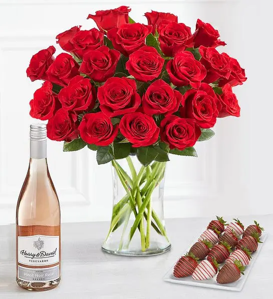 A photo of February birthday with a bouquet of roses next to a bottle of wine and a plate of chocolate-covered strawberries.