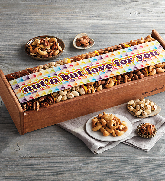 A photo of gifts for couples with a box full of nuts surrounded by five bowls of nuts.